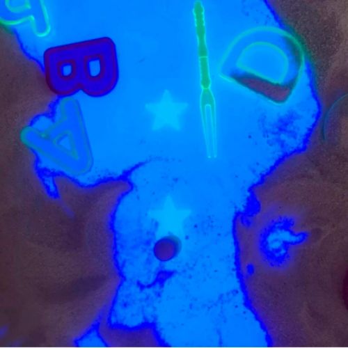 Imagen de mancha azul con letras sobre arena