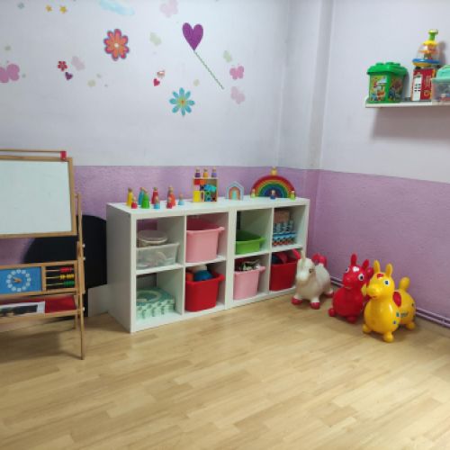 Aula grande con paredes de color blanco y rosa y decoración con flores