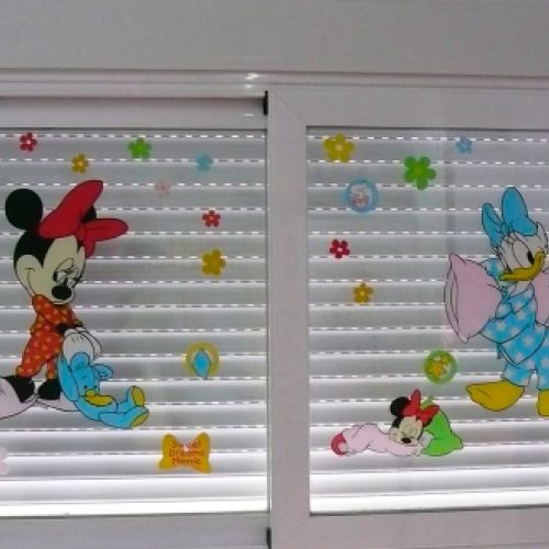 Ventanas con persianas cerradas y vinilos de disney en los cristales