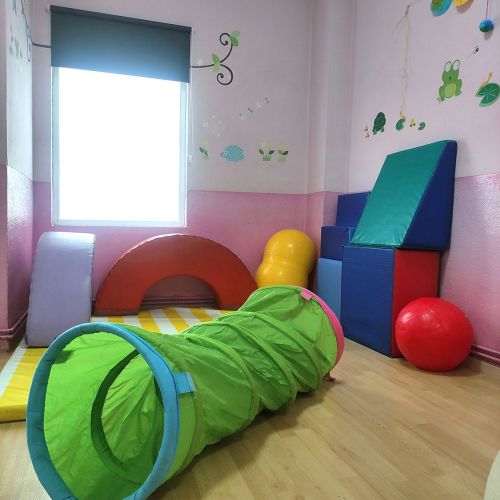 Aula con suelo de madera y accesorios para hacer juegos de psicomotricidad