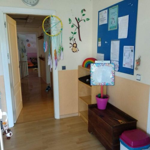 Recibidor de la escuela con tablón de anuncios y puerta blanca