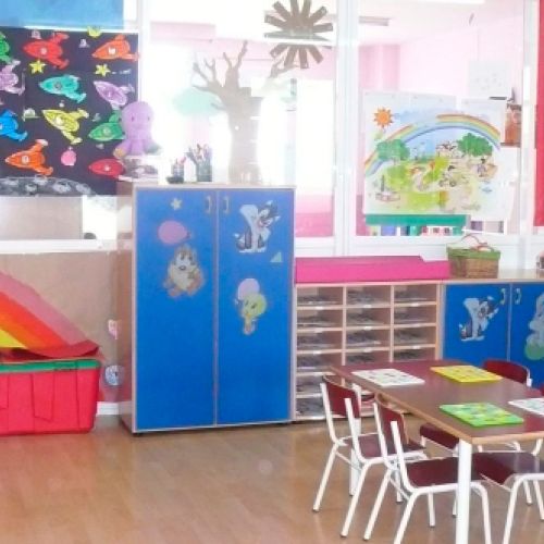 Aula grande con estanterías y mesas con cuatro sillas