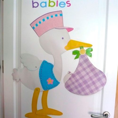 Puerta blanca con dibujo y texto de cigúeña