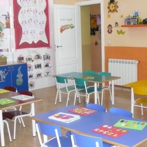 Aula grande con varias mesas rectangulares y sillas